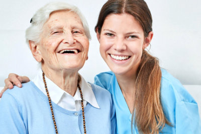 a social worker and senior woman smiling together