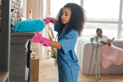 a home health aide cleaning the house of the patient