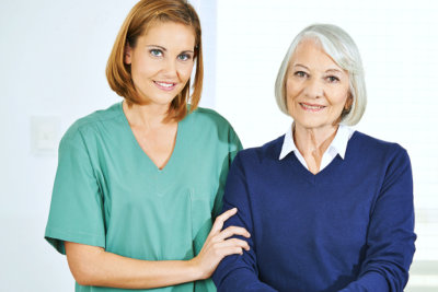 caregiver taking care of an elderly, posing for a picture at home