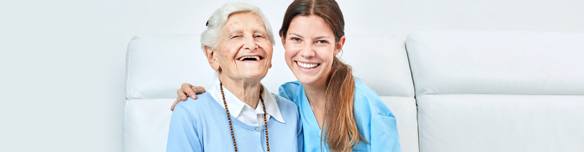 a social worker and senior woman smiling together