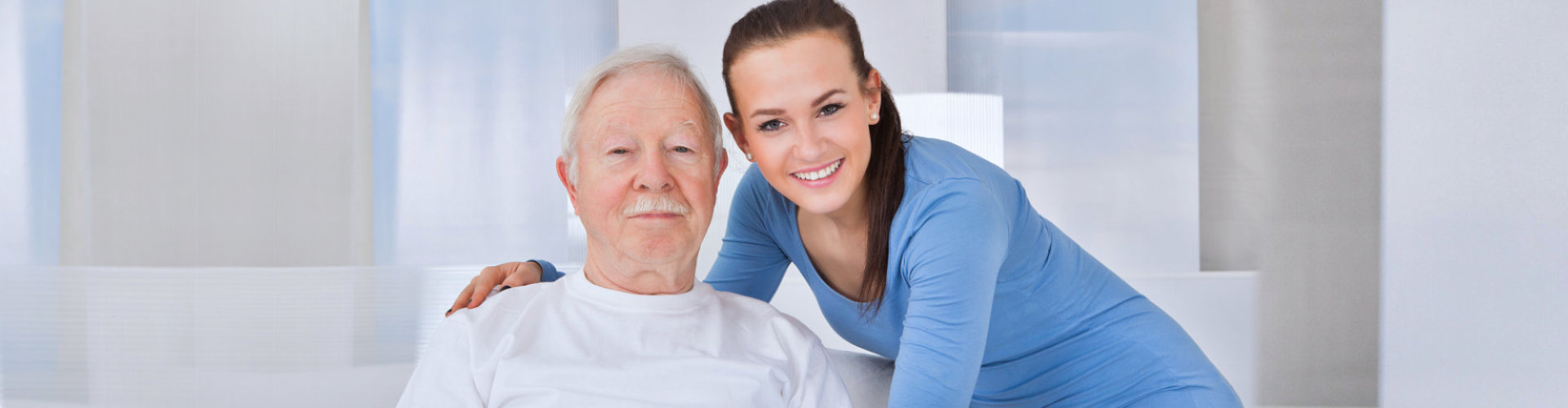 senior man and caregiver smiling